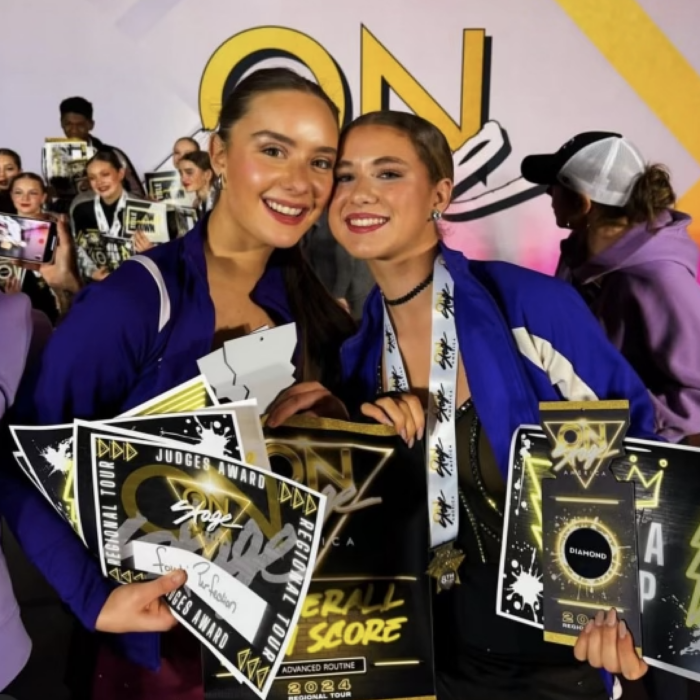 Two dancers holding awards